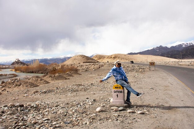 Visita de viagem de mulher tailandesa de viajantes para tirar foto com marco retrô na distância de informações rodoviárias em Leh Manali e Srinagar Leh Highway em Leh Ladakh em Jammu e Caxemira, Índia