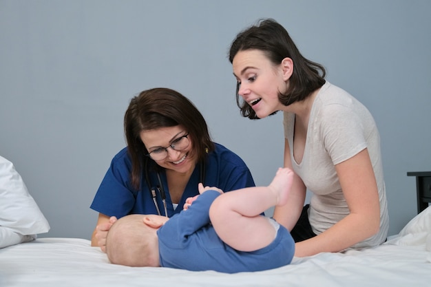 Visita do pediatra à mãe e ao bebê em casa. médico falando e jovem mãe