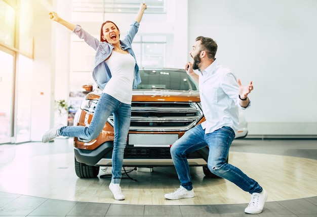 La visita exitosa al concesionario Feliz pareja joven elige y compra un auto nuevo para la familia