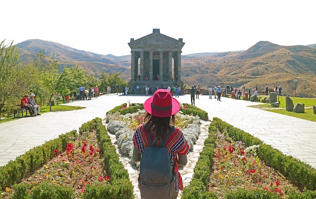 Visitante feminina olhando para a linda arquitetura do Templo de Garni Armênia