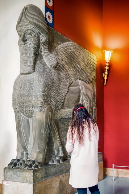 Visitante mirando asirio Lamassu o toro alado en el museo de Pérgamo en la ciudad de Berlín en Alemania