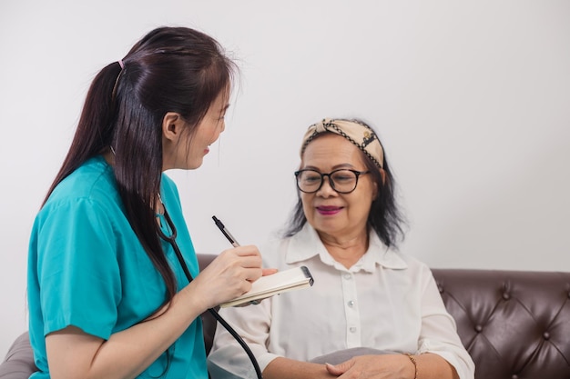 Visitante de salud y una mujer mayor durante la visita al hogar