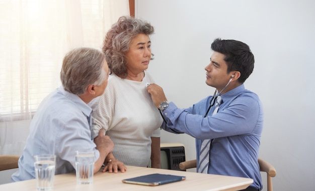 Visitante de salud y mujer mayor durante la visita al hogar.