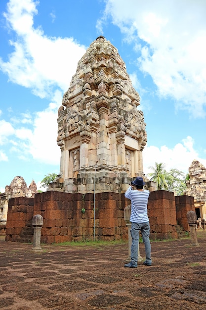 Visitante tomando fotos de las ruinas de la torre principal del antiguo templo Khmer de Sdok Kok Thom, Tailandia