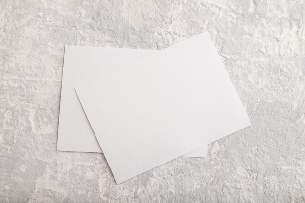Foto visitenkartenmodell aus weißem papier auf grauem betonhintergrund leere flache ansicht von oben