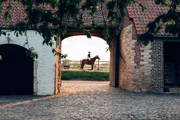 Vislumbre de um típico cavaleiro europeu medieval de construção de fazenda a cavalo no fundo