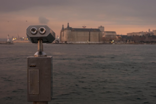 Foto visor binocular que funciona con monedas junto al paseo marítimo frente al barco.