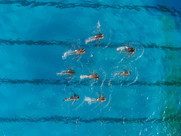 Vista aérea de la actuación de nadadores sincronizados grupales con piernas