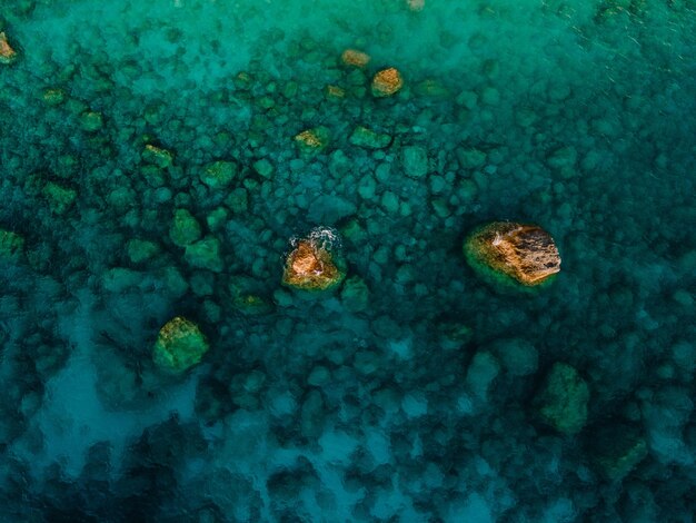 Vista aérea del agua azul clara de la playa rocosa del mar