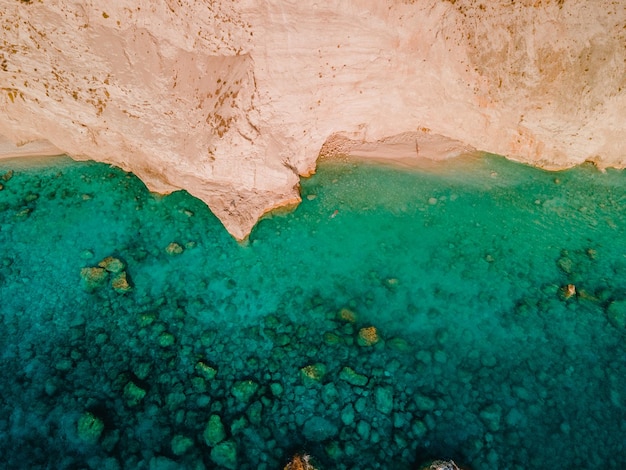 Vista aérea del agua azul clara de la playa rocosa del mar
