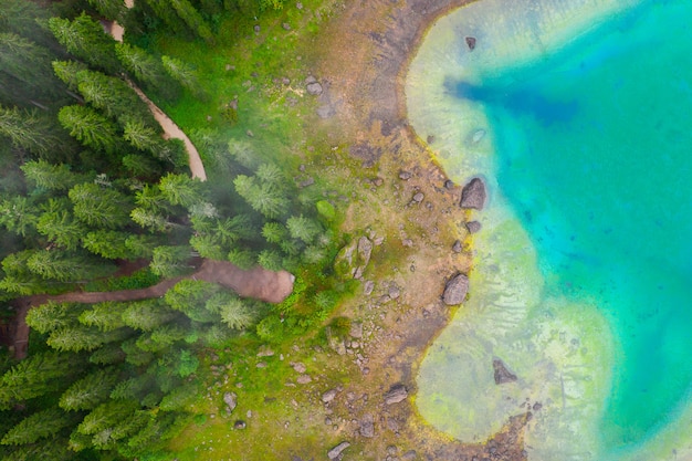 Vista aérea del agua azul turquesa del lago Carezza en los Alpes Dolomitas. Lago di Karersee cerca del bosque de abetos.