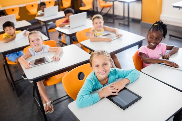 Vista aérea de alumnos que trabajan con laptop y tablet pc