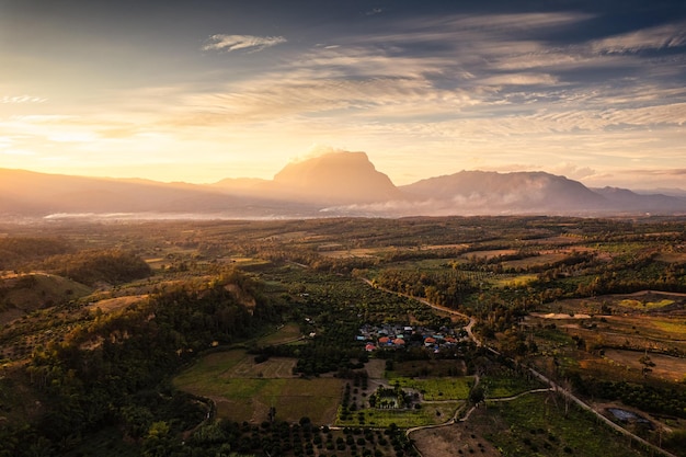 Vista aérea del amanecer brillando en la montaña Doi Luang Chiang Dao con niebla en tierras de cultivo en el campo en Chiang Dao, Chiang Mai