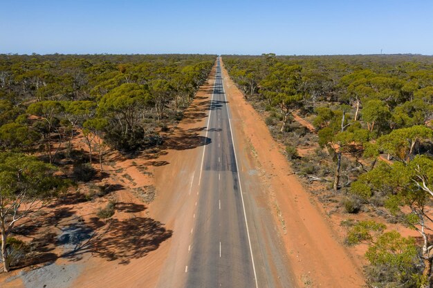 Foto vista aérea de bajo ángulo de una larga carretera recta en el interior de australia en australia occidental