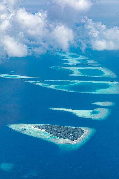 Vista aérea de los arrecifes de coral en las islas Maldivas Paisaje aéreo tropical Vacaciones de verano de lujo