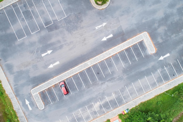 Vista aérea de arriba hacia abajo del automóvil SUV rojo estacionado en un estacionamiento de automóviles de hormigón con una línea blanca de señal de tráfico en la calle Vista superior del automóvil en fila en el espacio de estacionamiento Área de estacionamiento de automóviles exterior