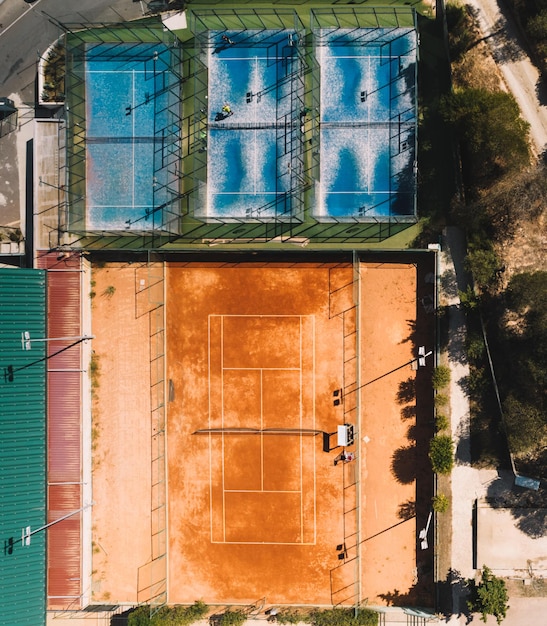 Vista aérea desde arriba hacia abajo de las canchas de tenis y pádel en un área deportiva pública