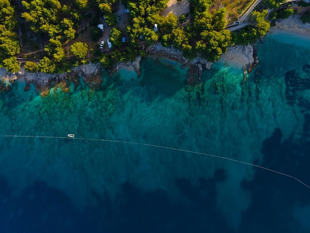 Vista aérea de arriba hacia abajo en la costa del mar Adriático con camping en el bosque Isla de Brac Croacia Resort de vacaciones de verano