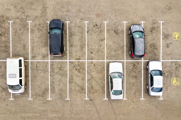 Vista aérea de arriba hacia abajo de muchos coches en un estacionamiento del supermercado