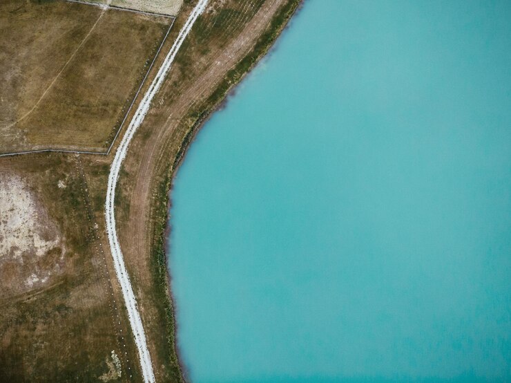 Vista aérea de arriba hacia abajo sobre el lago y el camino rural