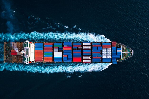 Foto vista aérea de arriba de un buque contenedor a toda velocidad en el mar azul profundo para la importación y exportación de logística de carga