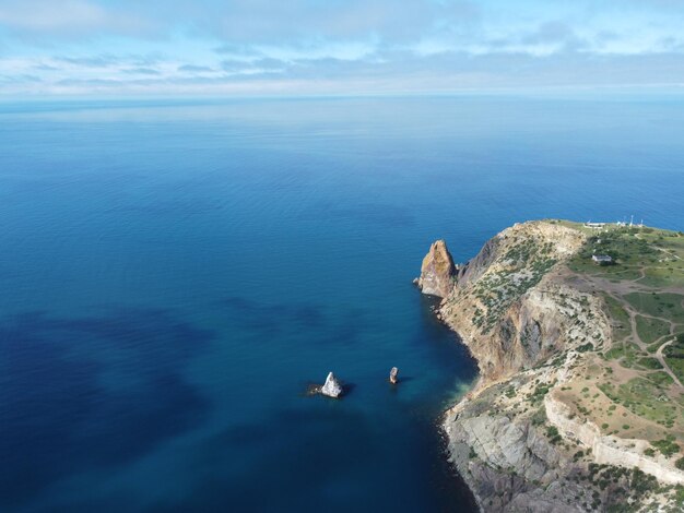 Vista aérea desde arriba sobre el mar azul y las costas rocosas volcánicas pequeñas olas en la superficie del agua en movimiento