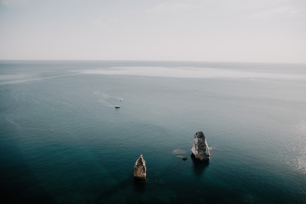 Vista aérea desde arriba sobre el tranquilo mar azul y costas rocosas volcánicas pequeñas olas sobre la superficie del agua en