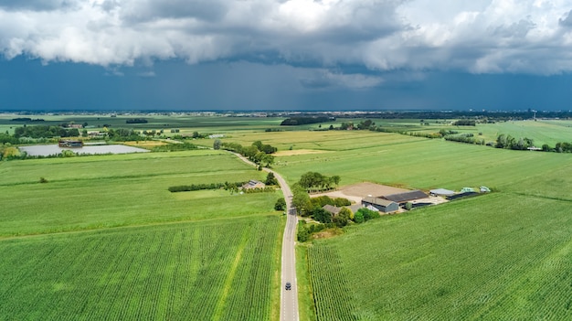 Vista aérea de aviones no tripulados de campos verdes y casas de campo cerca del canal desde arriba, típico paisaje holandés, Holanda, Países Bajos