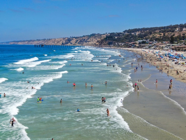 Vista aérea de la bahía de La Jolla con bonitas olas pequeñas y turistas disfrutando del día de playa