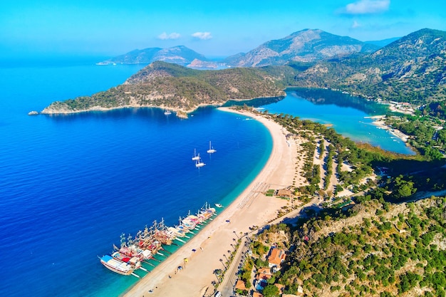 Vista aérea de la bahía del mar Mediterráneo con playa de arena de montaña y barcos en un día soleado en verano Foto de Drone de la laguna azul en Oludeniz Turquía