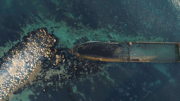 Vista aérea del barco hundido oxidado atrapado en un banco rocoso Viejo buque de mar