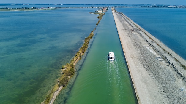 Vista aérea de barcos en el canal en la laguna del mar Mediterráneo Etang de Thau agua desde arriba, viaje en barcaza en el sur de Francia