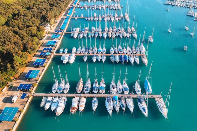 Vista aérea de barcos y yates de lujo en el muelle al atardecer en verano en Pula Croacia Paisaje colorido con veleros y lanchas en la bahía del mar jatty mar azul claro Vista superior del puerto Viajes