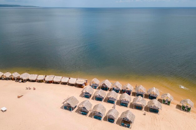 Foto vista aérea de cabañas de playa con techos de palma en la playa de pindobal a orillas del río tapajos