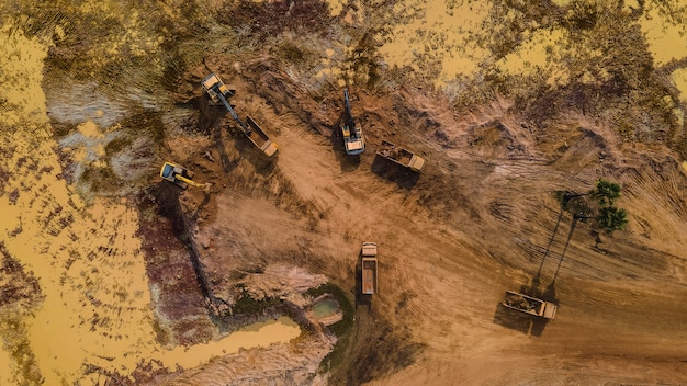 Vista aérea del camión y la excavadora o retroexcavadora trabajando en el sitio de construcción.