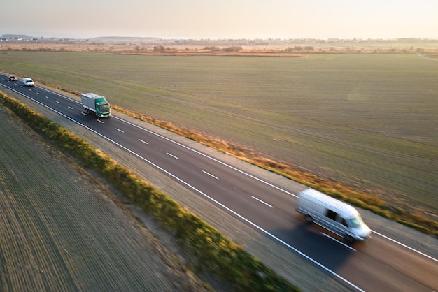 Vista aérea de camiones de carga que conducen por carretera que transportan mercancías Concepto de transporte y logística de entrega