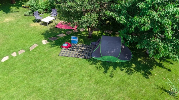 Vista aérea del campamento desde arriba, carpa y equipo de campamento bajo las vacaciones de la familia del árbol en el concepto de campamento al aire libre