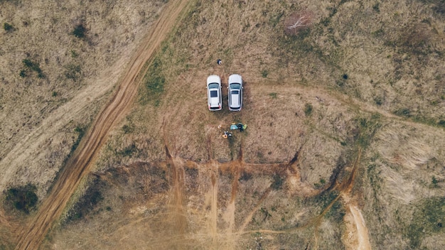 Vista aérea del camping dos coches suv con sillas de camping. gente descansando al aire libre. amigos juntos actividades