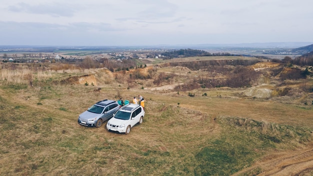 Vista aérea del camping dos coches suv con sillas de camping. gente descansando al aire libre. amigos juntos actividades