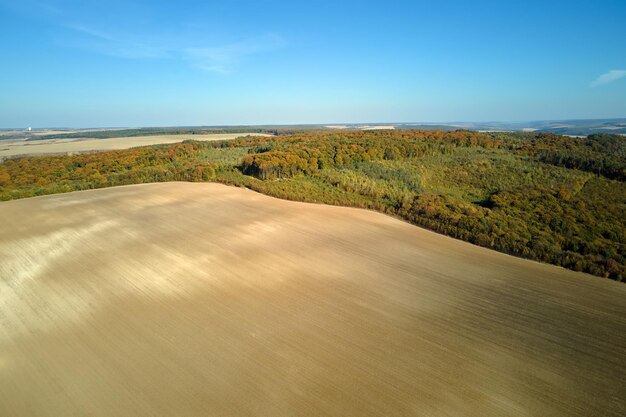 Vista aérea del campo agrícola arado con suelo fértil cultivado preparado para plantar cultivos en primavera