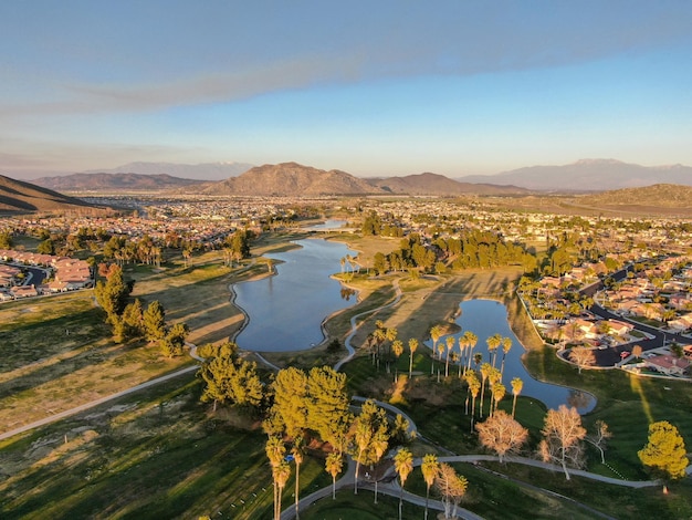 Vista aérea del campo de golf rodeado de casas adosadas y villas de lujo durante la puesta de sol Temecula