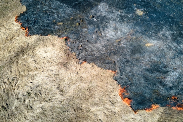 Vista aérea del campo de pastizales ardiendo con fuego rojo durante la estación seca Desastre natural y concepto de cambio climático