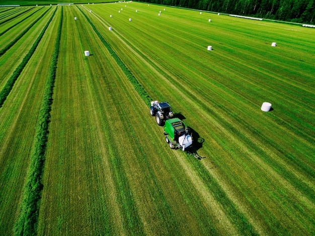 Vista aérea del campo verde de siega del tractor en verano Finlandia