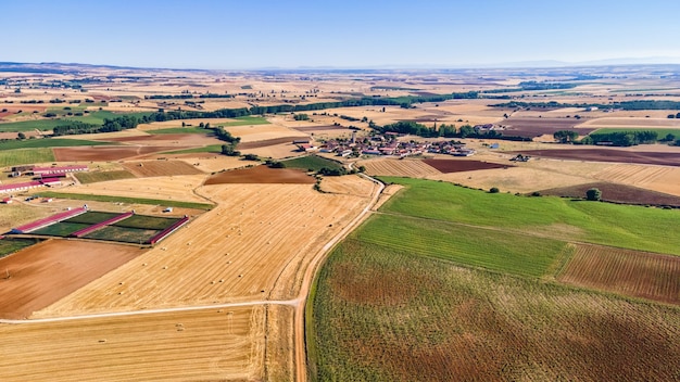 Vista aérea de campos agrícolas y pueblo rural al fondo. Segovia.