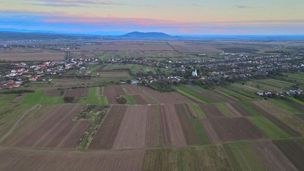 Vista aérea de los campos de otoño con cabañas de tierras de cultivo alrededor del pequeño pueblo hermoso l