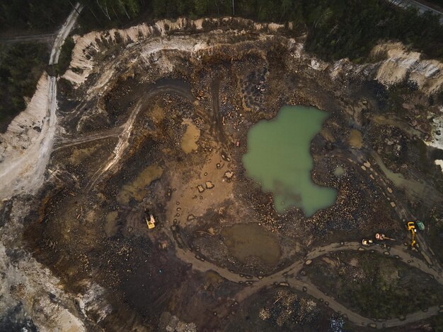 Foto vista aérea de la cantera de basalto a cielo abierto con excavadora e industria automotriz de la cantera de piedra de basalto negro