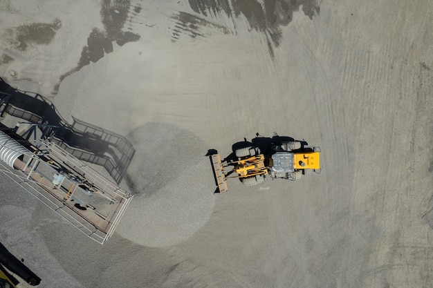 Vista aérea de cargadores de arena están paleando rocas en camiones volquete