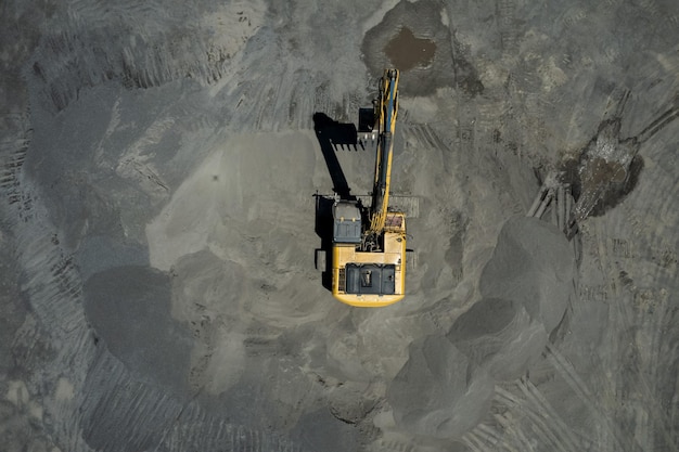 Vista aérea de cargadores de arena están paleando rocas en camiones volquete