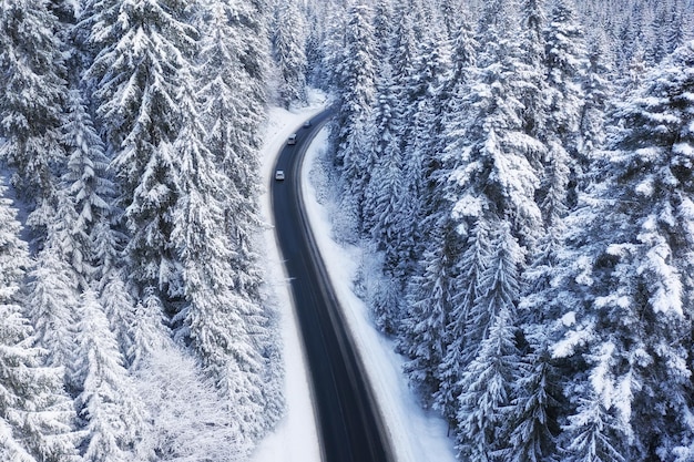 Vista aérea de la carretera y el bosque en invierno Paisaje natural de invierno desde el aire Bosque bajo la nieve en invierno Paisaje desde drone