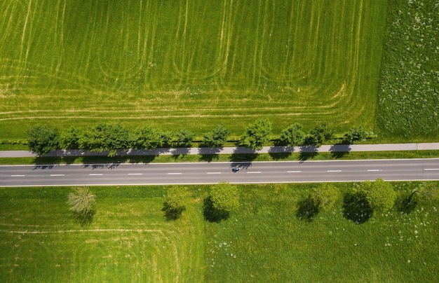 Vista aérea de la carretera de dos carriles a través del campo y campos de cultivo. Disparo de drones y espacio de copia para texto